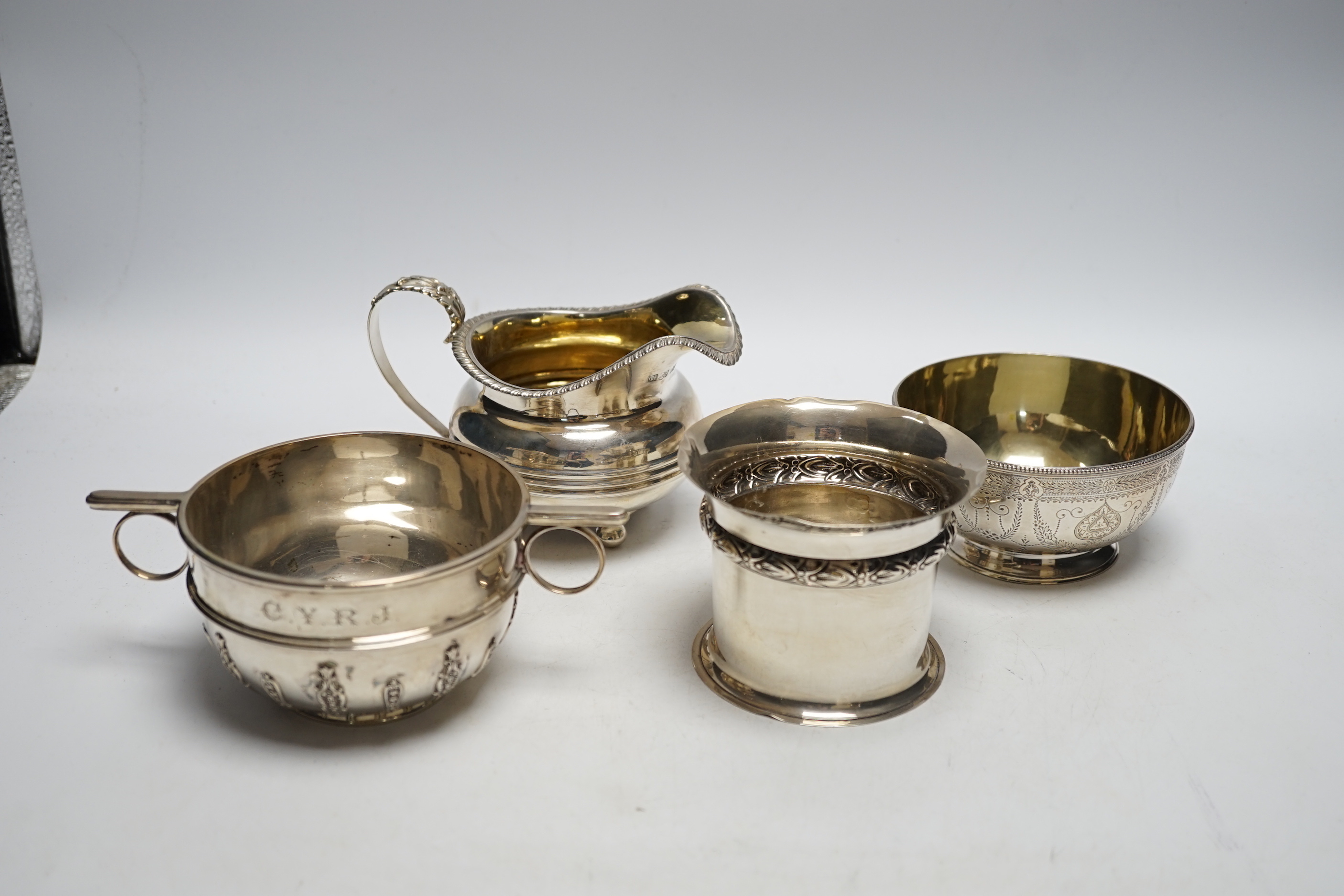 Two silver sugar bowls, London, 1877 and London, 1904, the latter with ring handles, diameter 10.8cm, a silver small vase and a George IV silver cream jug, 21.9oz.